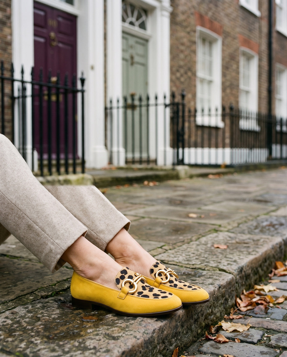 Close-up of feet wearing the animal print slippers, seated on a stone step