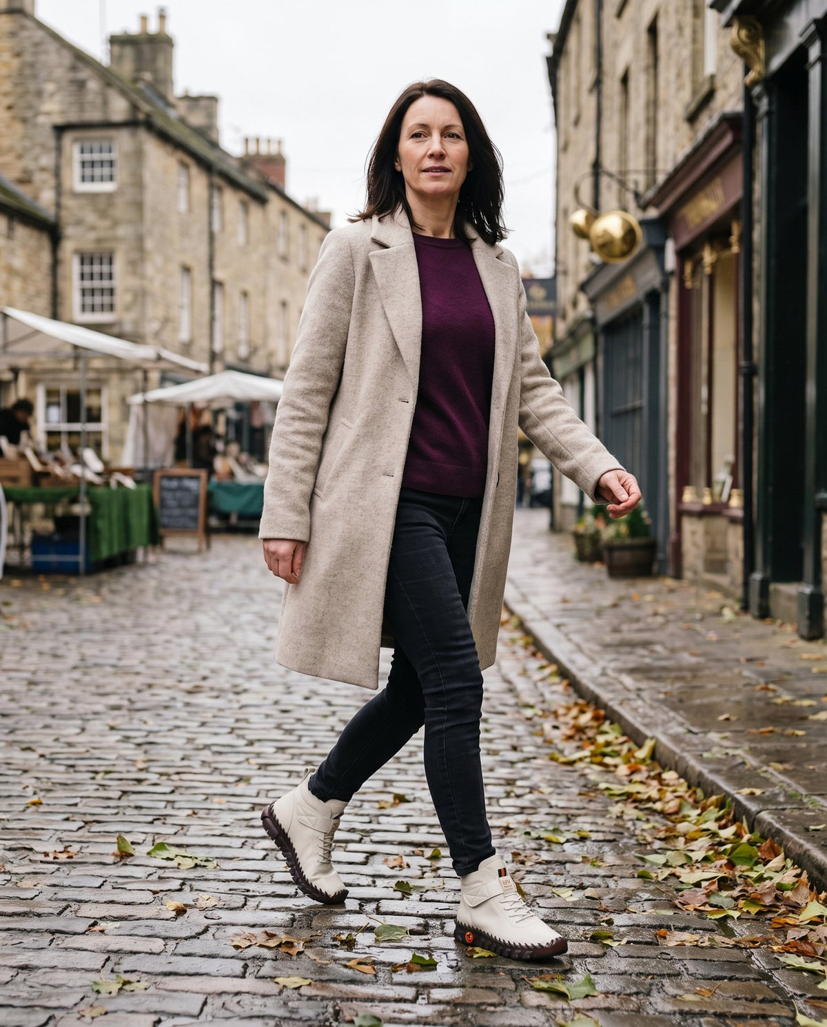 Claire wearing the white lace-up ankle boots on a cobbled street