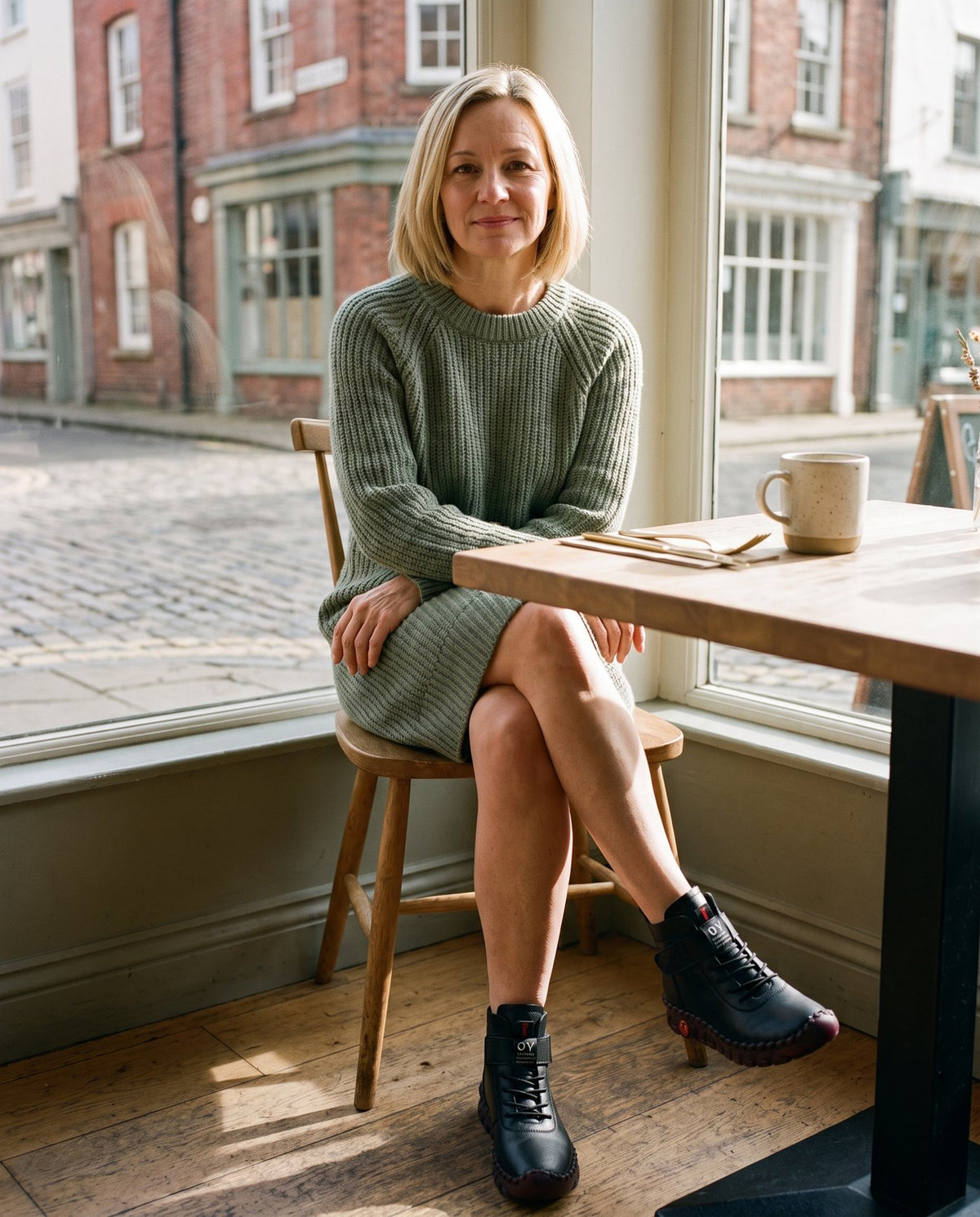 Sophie wearing the black lace-up ankle boots at a café Image