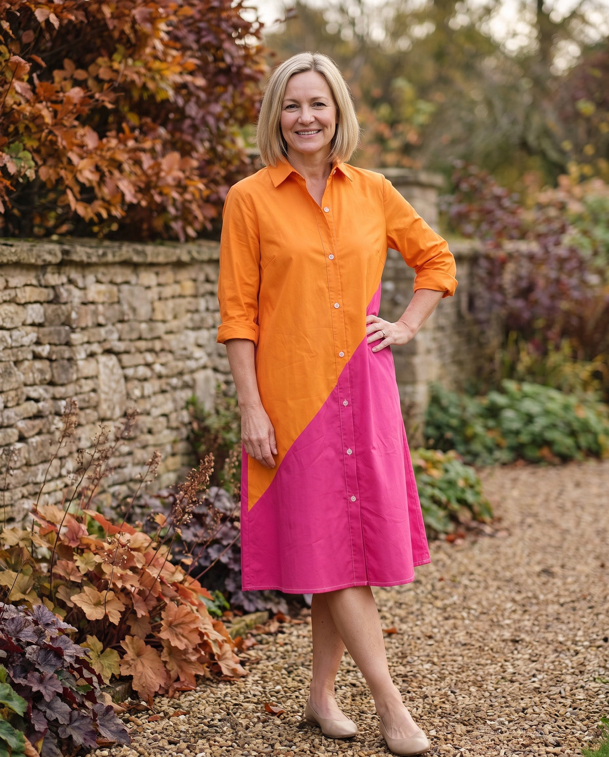 Woman wearing the colorblock button-front shirt midi dress with pockets in an autumn English garden Image