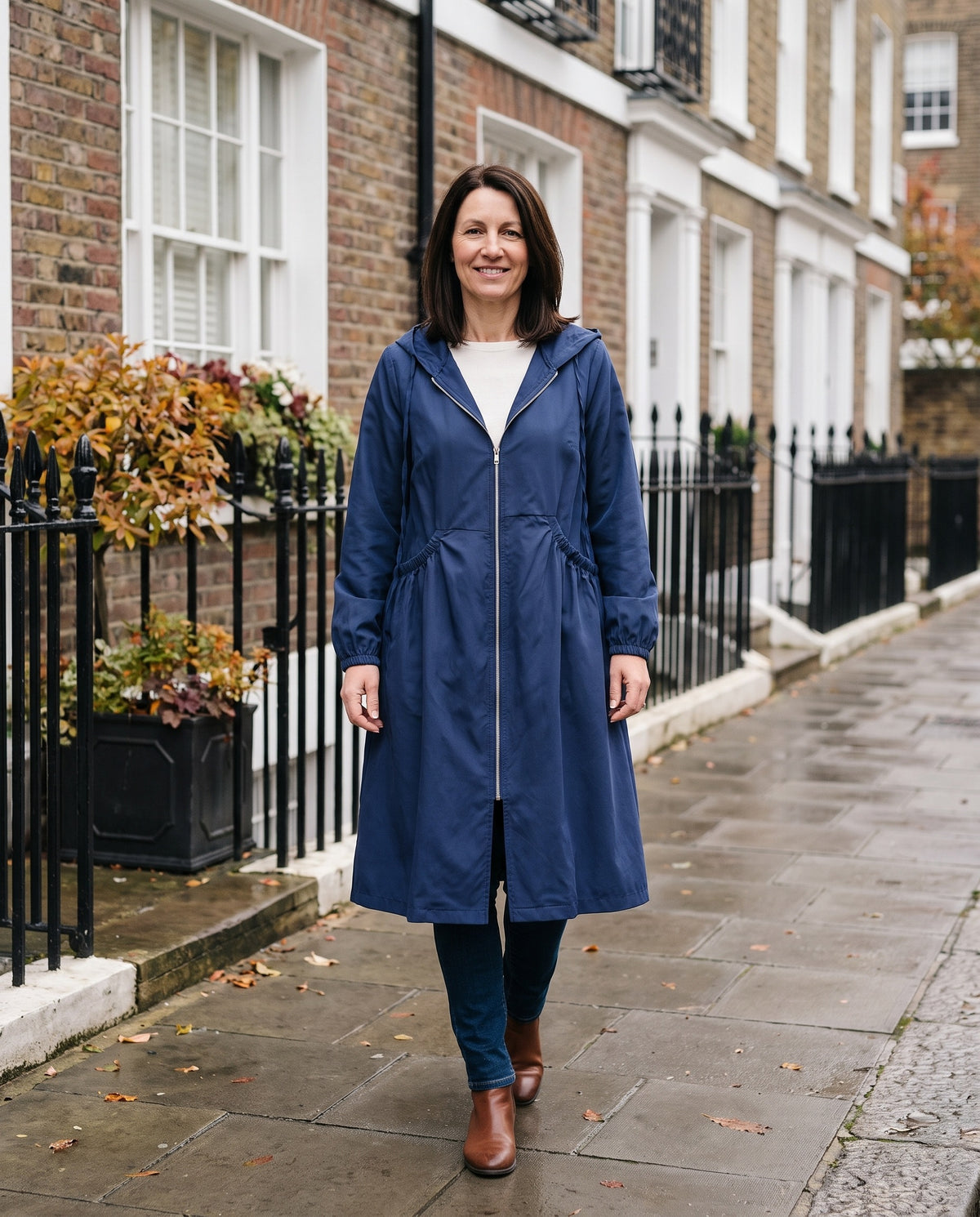 Woman wearing the plus size hooded coat with drawstring waist on an English residential street Image