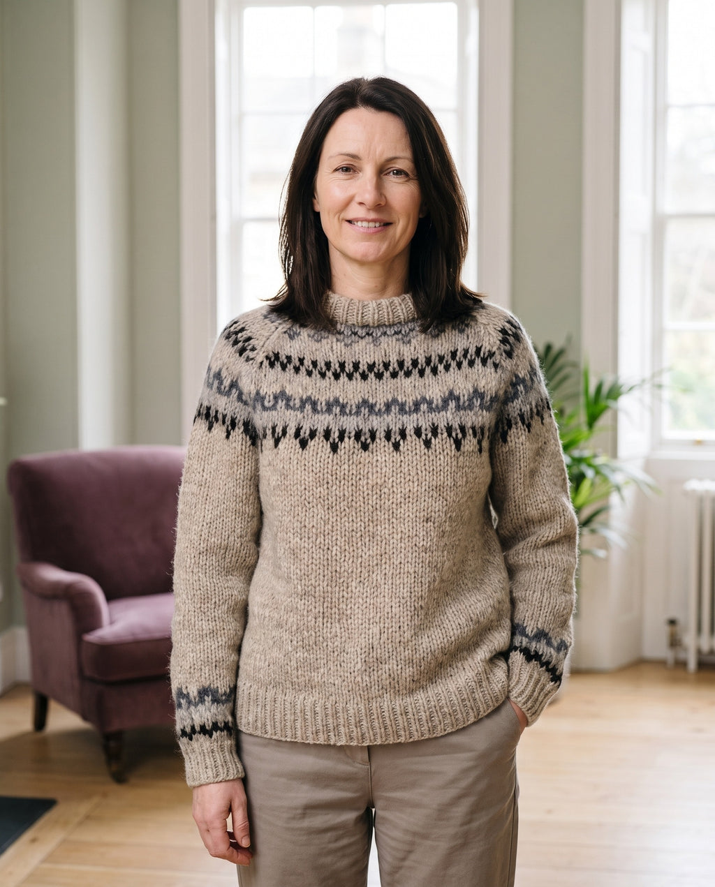 Woman wearing the nordic yoke knit jumper with funnel neck in a bright Georgian interior
