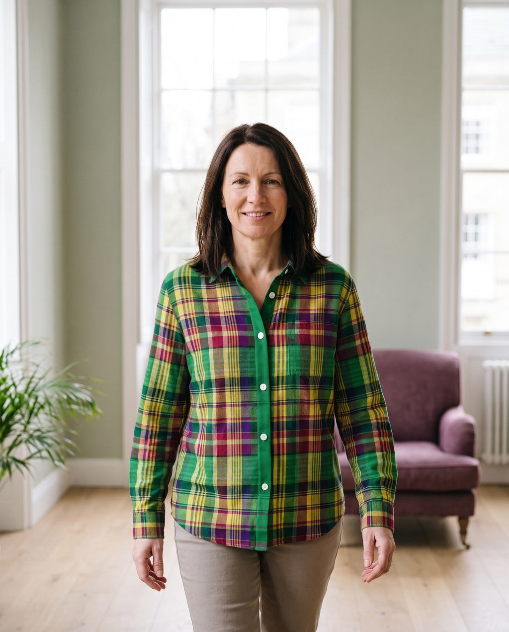 Woman wearing the checked blouse in vibrant green tones in a bright Georgian interior