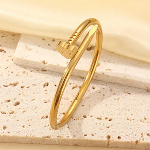 Gold-tone nail bangle on a stone stand