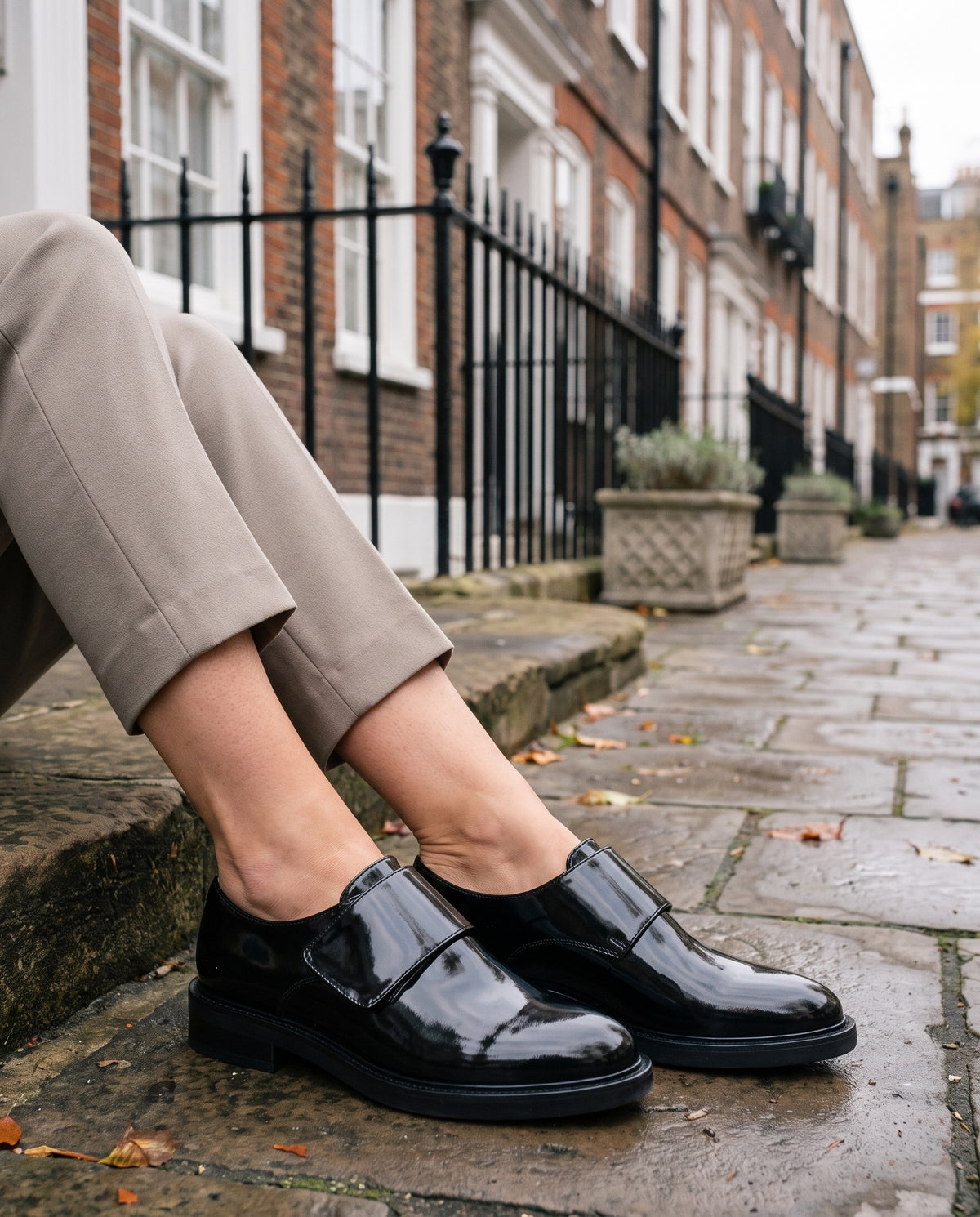 Close-up of feet wearing the orthopaedic patent-look strap shoes, mirror finish, seated on a stone step Image