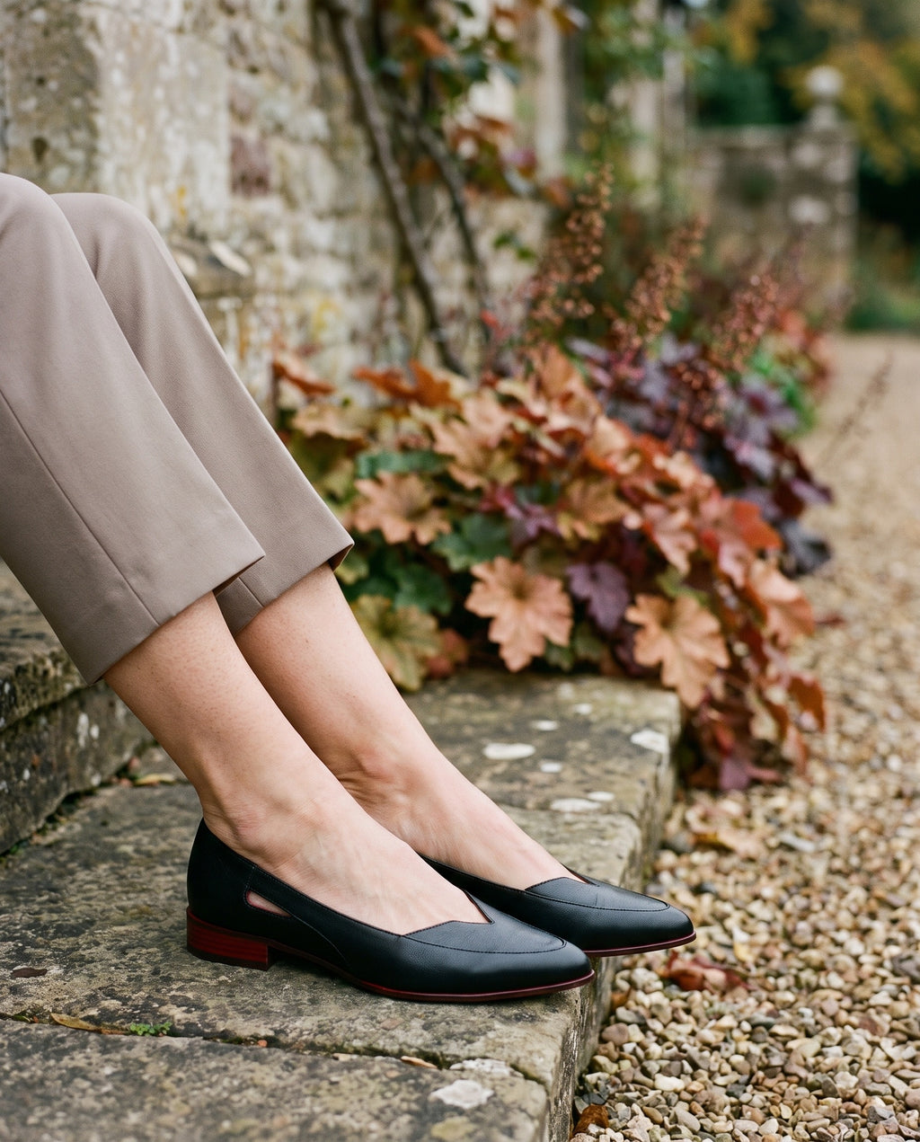 Close-up of feet wearing the elegant sandals, seated on a stone step