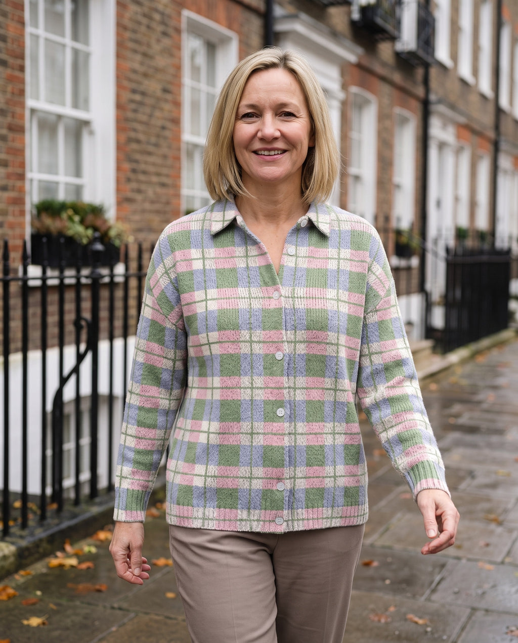 Woman wearing the checked knitted blouse in fresh pastel shades on an English residential street