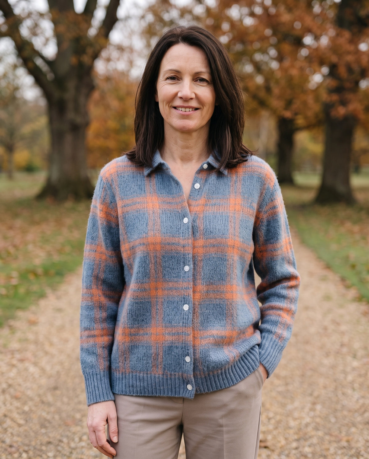 Woman wearing the blue check knitted shirt with collar in an English park in autumn