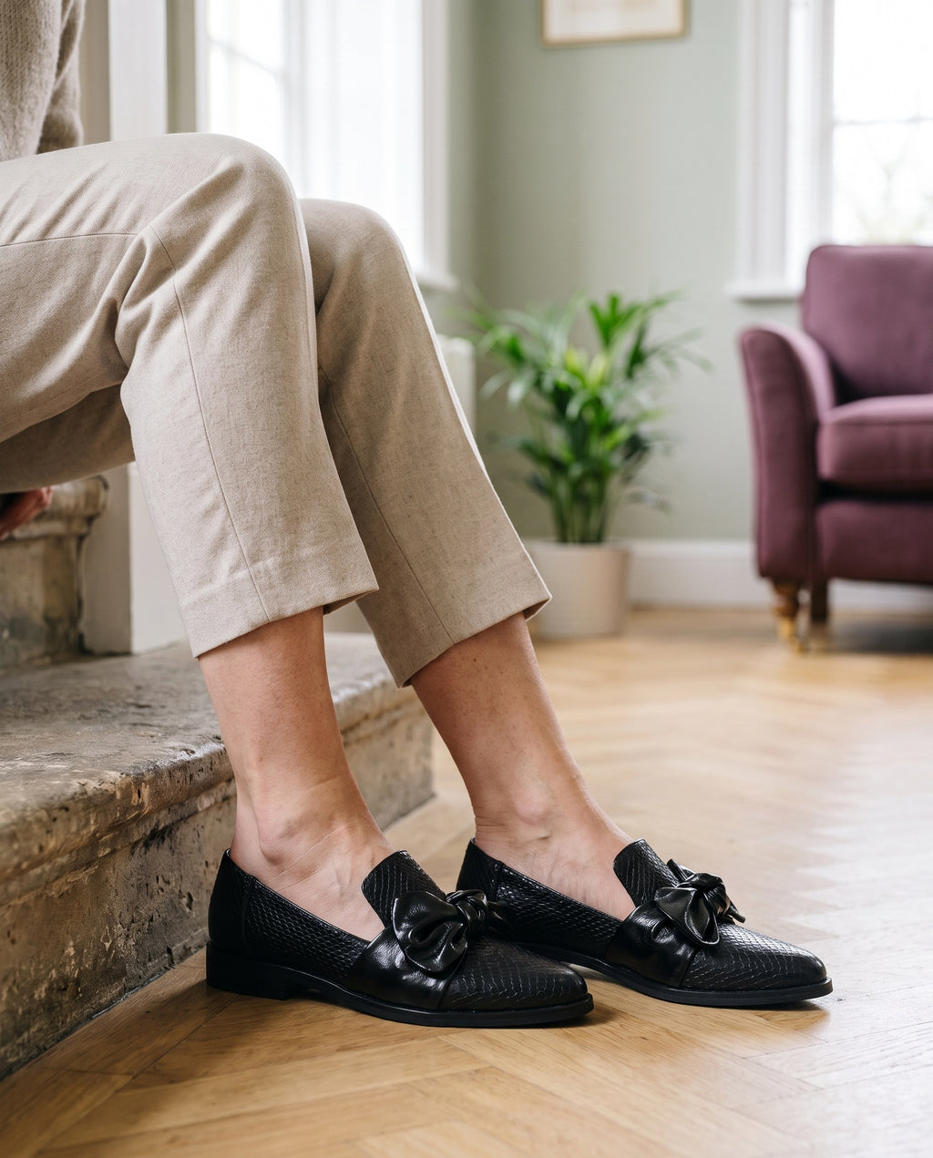 Close-up of feet wearing the elegant loafers, seated on a stone step
