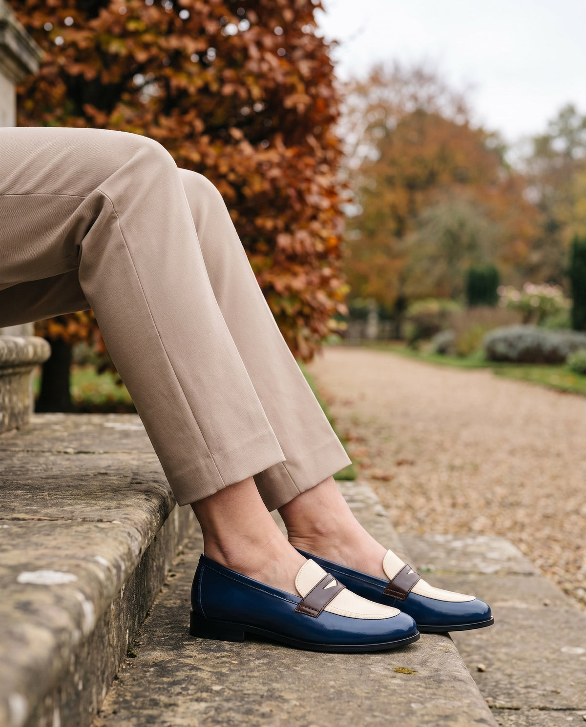 Close-up of feet wearing the lightweight comfort loafers, seated on a stone step Image