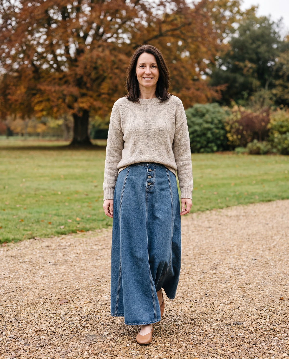 Woman wearing the denim maxi skirt with button front in an English park in autumn