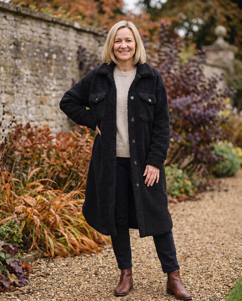 Woman wearing the longline teddy shirt coat with button front in an autumn English garden