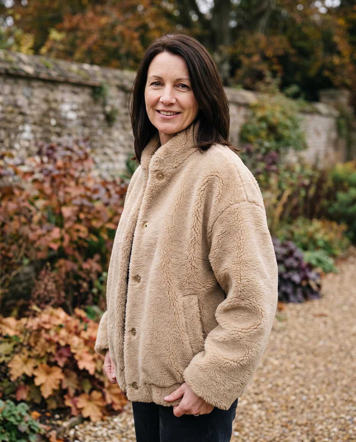Woman wearing the oversized teddy jacket with button closure, close-up of the neckline and fabric