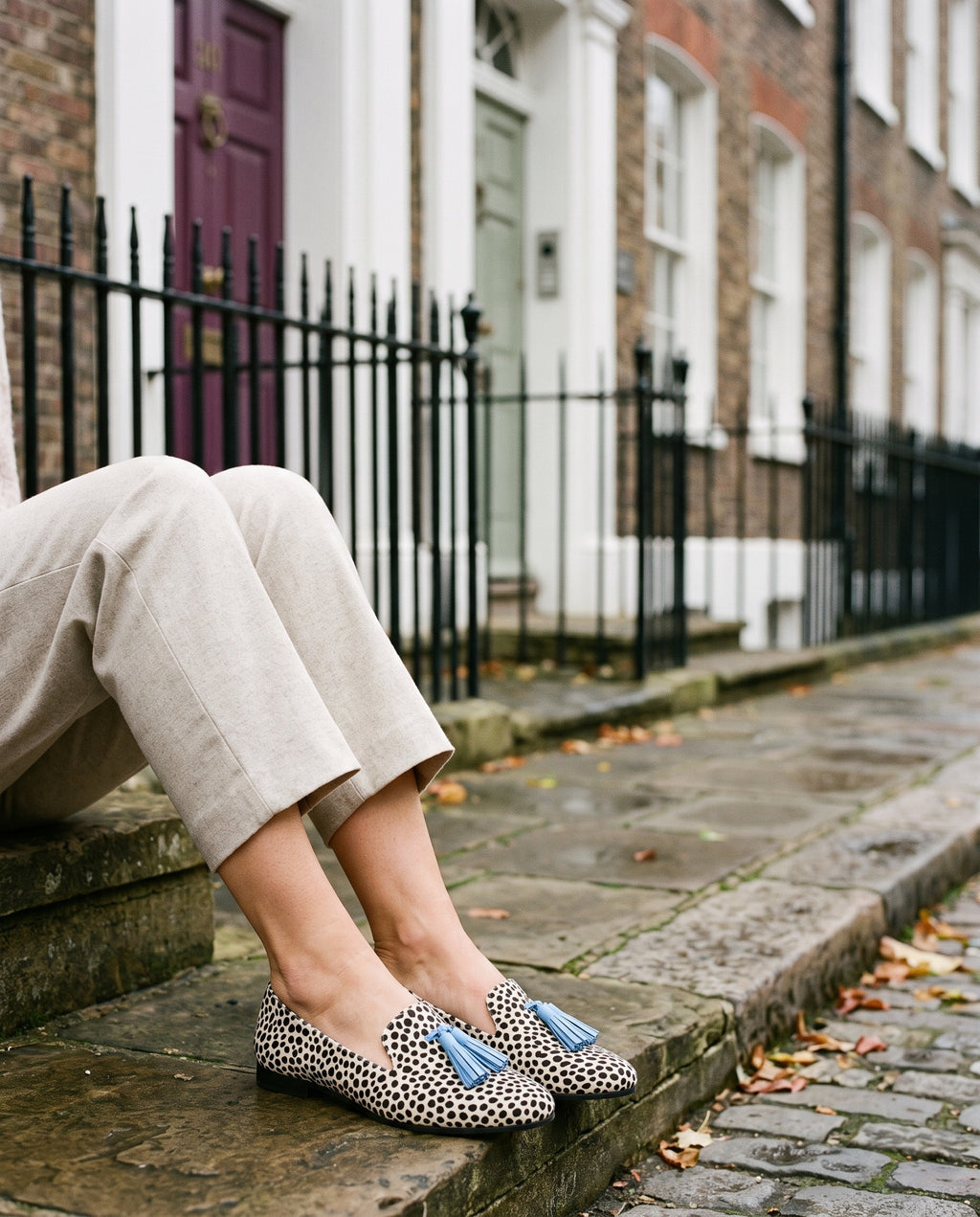 Close-up of feet wearing the refined comfort loafers, seated on a stone step